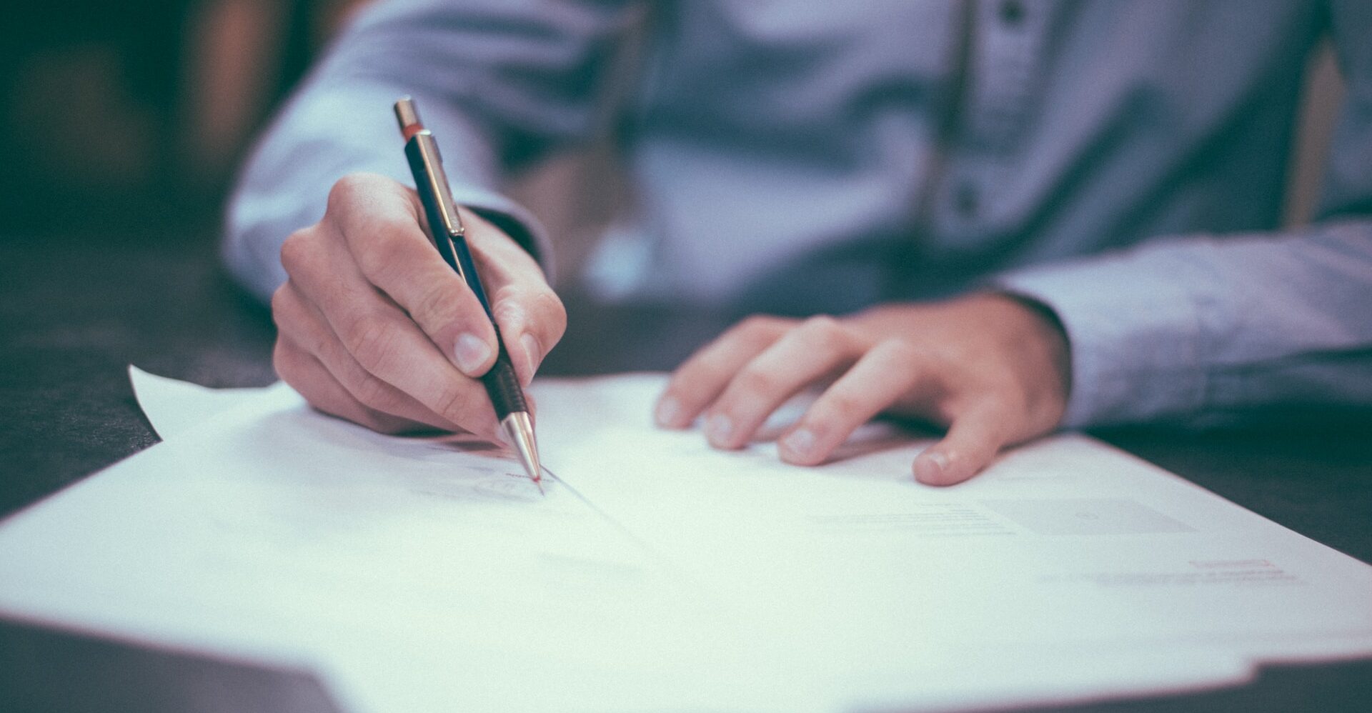 Man with pen signing a surety bond form